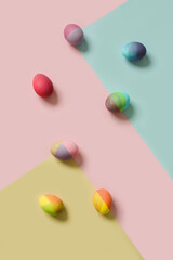 Pastel Easter eggs on a blue, pink, yellow background. Minimal creative concept of Easter.
