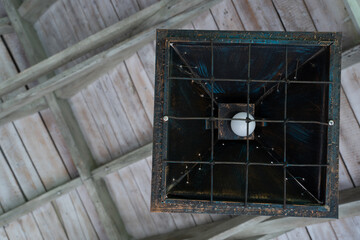 an old square wooden box on the ceiling that has been transformed into a lamp.