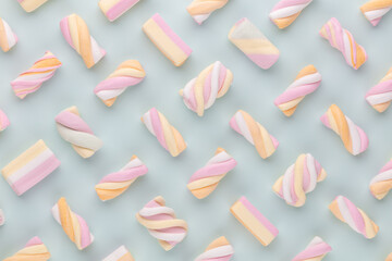 Colorful marshmallow laid out on pastel background. Creative textured pattern.