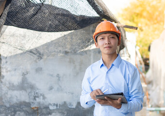 Young Asian foreman taking notes on his tablet, Business concept and technology.