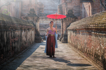 Beautiful Thai girl in Thai costume,Asian woman wearing traditional Thai culture at Tempple Ayutthaya, Thailand. - obrazy, fototapety, plakaty