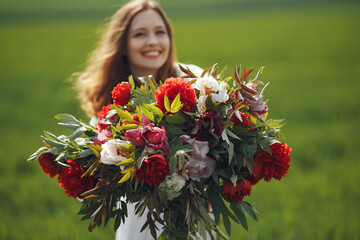 Naklejka premium Woman in elegant dress standing in a summer field