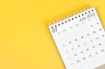 July 2022 desk calendar on yellow background with empty space.