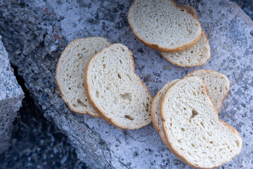 dried white bread stands on a stone surface outside on the street.