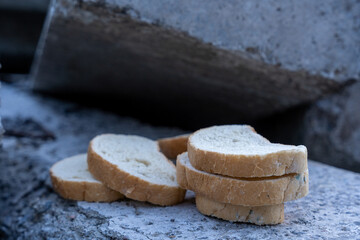 dried white bread stands on a stone surface outside on the street.