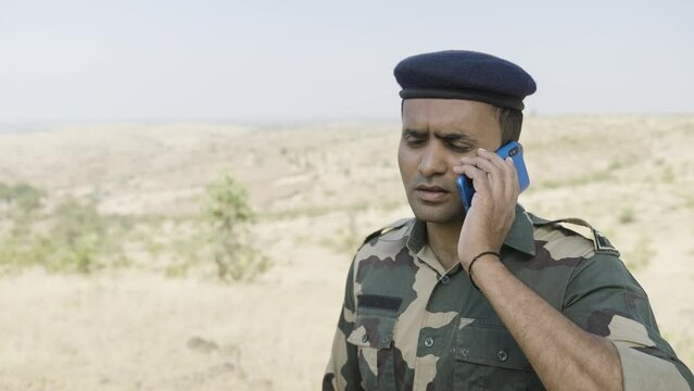 Panic soldier while talking on mobile phone during miliary service - concept of stressful, healthcare and professional occupation