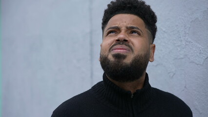 Man standing outside looking up to sky thoughtful person looks up