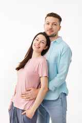 Fototapeta premium Portrait of a beautiful beloved couple. A guy and a girl hug each other and look at the camera smiling . On a white background