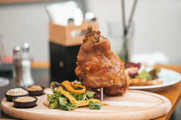 Roasted pork knuckle eisbein with salad and mustard on wooden cutting board - obrazy, fototapety, plakaty