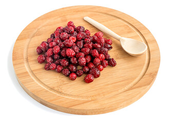 Dried tasty wholesome cranberry with a wooden spoon lies in bulk on a wooden light board. 