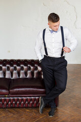 Attractive young man, future generation businessman stand near sofa and interested in searching work.