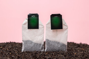 Loose tea and tea bags on a pink background. Large leaf tea. There is room for copy space