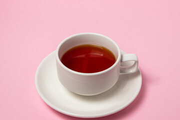 Cup of tea on a pink background. Invigorating and tonic tea drink.