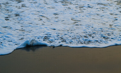 Soft Wave Of Blue Ocean On Sandy Beach. For using background. Selective focus. Sea Beach and Soft wave of blue ocean. Summer day and sandy beach background.