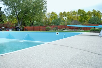 backyard swimming pool with diving board emptied out shutting down for winter