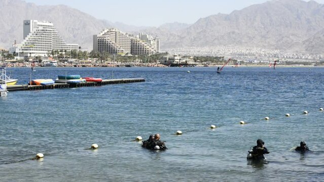 Divers prepare for underwater dive on coral reef near Eilat – famous tourist resort and recreational Israeli city, located on the Red Sea