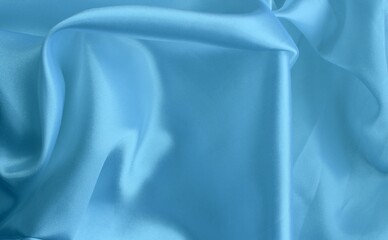 Blue satin background. Material with folds.