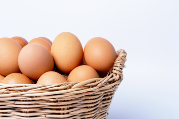 Fresh eggs collected inside wicker basket, suitable as a food ingredient. Fresh eggs from quality organic farms isolated on white background. Healthy food concept