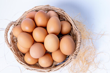 Fresh eggs collected inside wicker basket, suitable as a food ingredient. Fresh eggs from quality organic farms isolated on white background. Healthy food concept