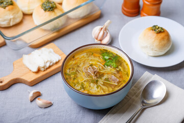 Shchi with pampushki (buns) and lard. Soup of cabbage, potatoes and meat. Traditional Russian and Ukrainian cuisine. Close-up.