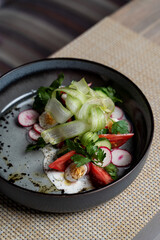 Goat cheese salad with cucumber stripes and bull heart tomatoes, gourmet salad in a posh restaurant