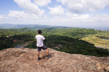 Fototapeta premium Man hiker with a backpack on top of the mountain back 