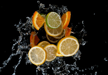 Freeze motion of sliced limes, oranges and lemons in water splash.