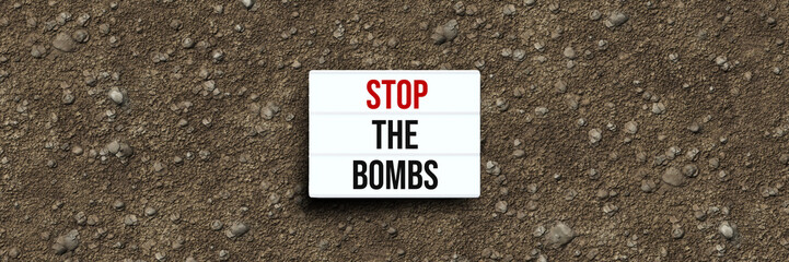 lightbox with the message STOP THE BOMBS on dirt gravel background