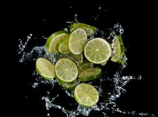 Freeze motion of sliced limes in water splash.