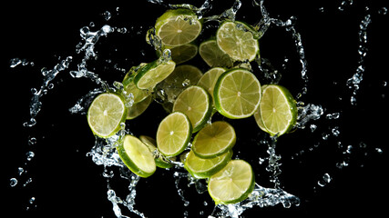 Fototapeta na wymiar Freeze motion of sliced limes in water splash.