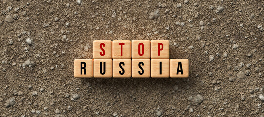 wooden blocks with the message STOP RUSSIA on dirt gravel background