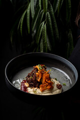 Shredded beef with potato puree, modern serving in a dark restaurant