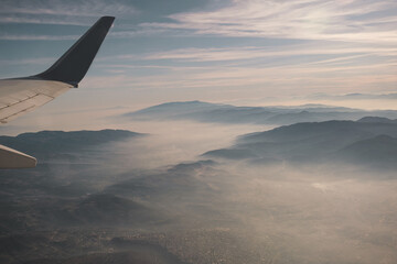 View of mountains from in airplane and airplane wing.