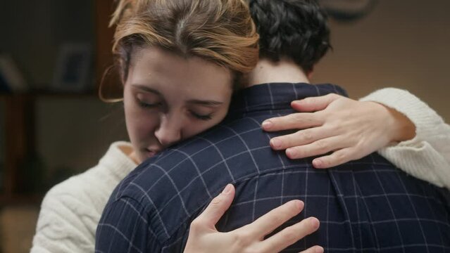 Man and woman hugging, wife forgiving husband. Young couple reconciling after conflict. Family problems, crisis in relationships. 