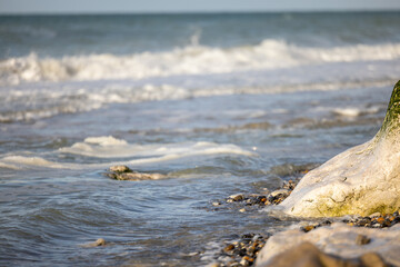 Crashing waves lapping on the sandy beach one after another under a blue sunset sky, selective focus used. High quality photo