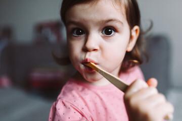 Little girl playing with wooden eco tooth brush