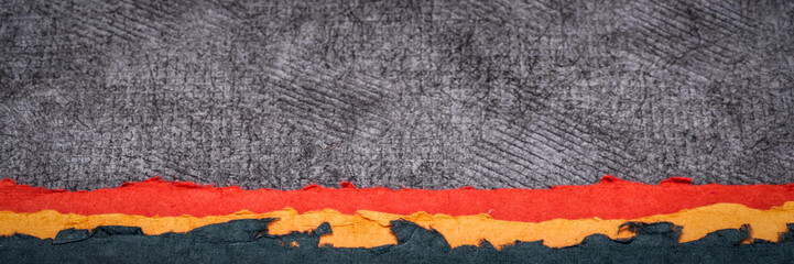 war zone abstract paper landscape - a collection of handmade papers in black, orange and red colors, panorama banner