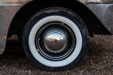 The white wall tire of a classic car that is slightly weathered in Winslow, Arizona.
