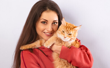 Beautiful happy smiling young woman holding on the hands and hugging with love her red maine coon kitten. Closeup portrait isolated on white background
