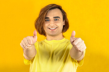 Young man Prep Student with long hair. Portrait of a guy on a yellow background