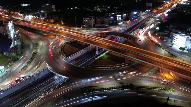 Hyperlapse time-lapse of car traffic transportation above circle roundabout road in Asian city. Drone aerial view fly in circle, high angle. Public transport or commuter city life concept