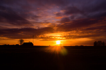 Fototapeta na wymiar A beautiful, colorful spring sunrise over the field. Seasonal scenery of Northern Europe.