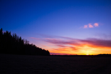 A beautiful, colorful spring sunrise over the field. Seasonal scenery of Northern Europe.