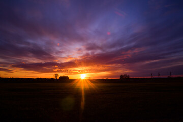 A beautiful, colorful spring sunrise over the field. Seasonal scenery of Northern Europe.