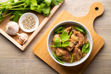 Baked Pork Ribs with Glass Noodles.Thai Style marinade pork by mixing the oyster sauce and soy sauce,topping with celery in white bowl.Top view