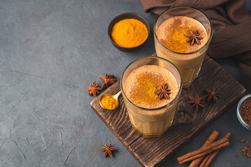 Indian latte with turmeric and cinnamon on a dark background.
