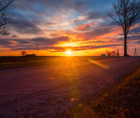A beautiful sun rising over the spring landscape in Northern Europe. Seasonal scenery of rural area.