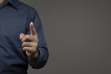 Close-up of business man's hand pointing finger at empty space for text, copy space, Businessman pointing finger on gray background.