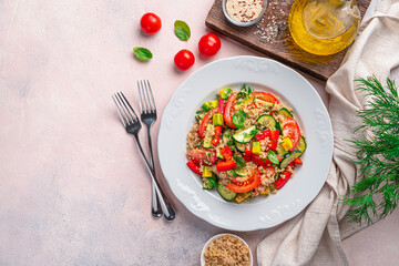 Vitamin salad with vegetables, quinoa, dill and basil on a light background.