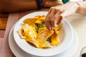 Un plato de nachos con queso, carne y guacamole